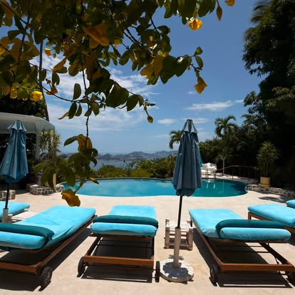 Pool and loungers at El Refugio overlooking Acapulco Bay