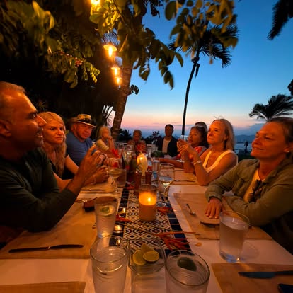 Guests sharing an outdoor dinner together at El Refugio in the evening